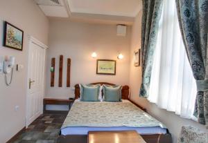 a bedroom with a large bed and a large window at Hotel Restaurant Odeon in Plovdiv