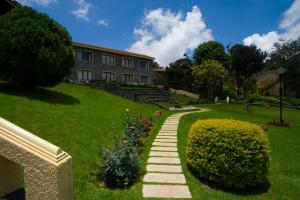 a garden with a stone path in front of a building at Green Pastures - A Hill Country Resort in Kodaikānāl