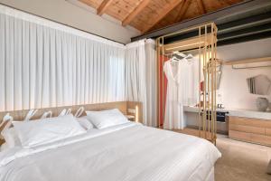a bedroom with a large white bed and a bathroom at Artblue Villas in Tsoukalades