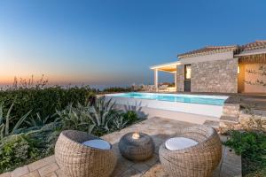 un patio trasero con piscina y sillas de mimbre en Artblue Villas, en Tsoukaladhes