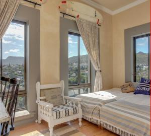 um quarto com uma cama e janelas grandes em Casa a Capri, Capri Village, Cape Town em Fish Hoek
