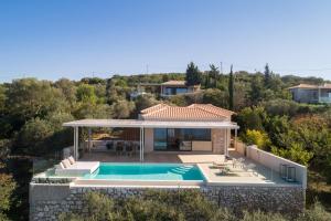 eine Villa mit einem Pool und einem Haus in der Unterkunft Artblue Villas in Tsoukaladhes