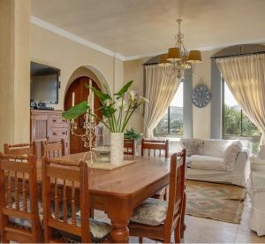 uma sala de estar com uma mesa de madeira e uma sala de jantar em Casa a Capri, Capri Village, Cape Town em Fish Hoek