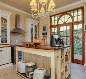 a kitchen with a large island with a microwave at Casa a Capri, Capri Village, Cape Town in Fish hoek