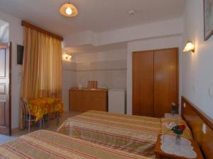 a hotel room with two beds and a table at Villa Koki Studios in Lindos