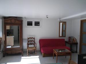 パッシーにあるAppartement en rez de jardin à la montagneのリビングルーム(赤いソファ、椅子付)