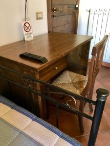 einen Holzschreibtisch mit Fernbedienung und einem Stuhl in der Unterkunft Ruviano La Torre in Ruviano