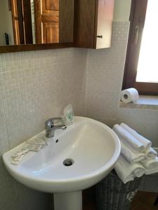 ein weißes Waschbecken im Bad mit Spiegel in der Unterkunft Ruviano La Torre in Ruviano