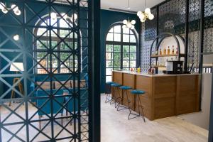 a room with blue walls and a bar with stools at Mirabel CityCenter Hotel in Argostoli