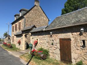an old stone building with flowers in front of it at Lo Soulenquo à Fonteilles sur le GR 65 in Golinhac