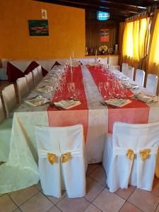 - une grande table avec des chaises blanches et des verres à vin dans l'établissement San Pietro, à Mileto