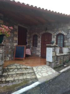a stone house with a stone porch and a brick building at Ξενώνας questhouse Electra isari in Isaris