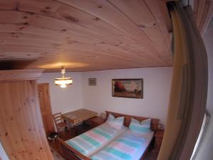 a bedroom with a bed and a wooden ceiling at Alt Jagthaus Schnetzer in Tweng