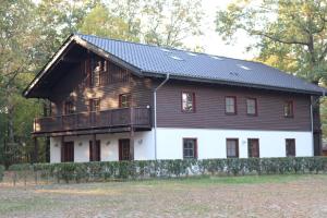a large wooden house with a balcony on top of it at Störitzland Betriebsgesellschaft mbH in Grünheide