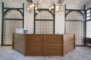 Mirabel CityCenter Hotel في أرغوستولي: كونتر خشبي في غرفة بها ثلاث نوافذ مقوسة