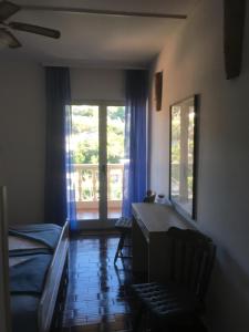 a room with a bed and a desk and a window at Seaview Antonija in Veli Lošinj
