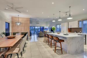 an open kitchen and dining room with a large table and chairs at Luxury Darwin City Lights Jacuzzi Central Location Large House New Furnishings in Darwin