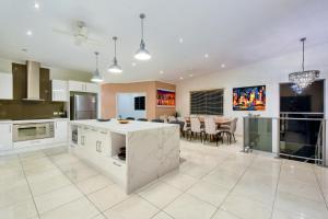 a large kitchen and dining room with a table at Luxury Darwin City Lights Jacuzzi Central Location Large House New Furnishings in Darwin