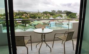 a balcony with a table and chairs and a view at Simplitel in Karon Beach
