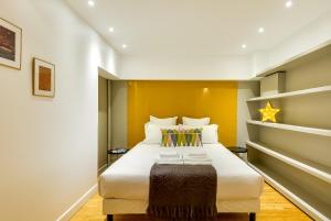 a bedroom with a large white bed with yellow walls at LE VAUGIRARD - 3bedrooms Apartment Premium in Paris