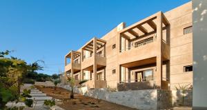 a large wooden building with trees in front of it at Eva Mare Hotel & Suites - Adults only in Agia Pelagia