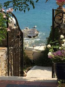 a boat in the water next to a gate at Roditses Beach Sea Front Apartments in Samos