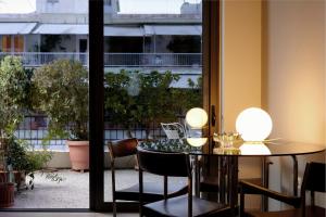 a dining room with a table and chairs and a window at Two level apartment with panoramic view in Athens