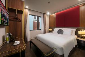 Un pat sau paturi într-o cameră la Hanoi L'Heritage Diamond Hotel & Spa