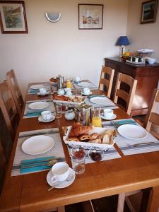 une table en bois avec des assiettes et de la nourriture dans l'établissement Numéro 34, à Burie