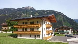 a building with wooden balconies and a mountain at Apart Geisler in Mayrhofen