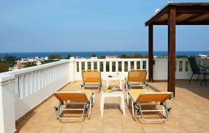 Un patio con sillas y una mesa en un balcón. en Kouros Chania Villas, en Máleme