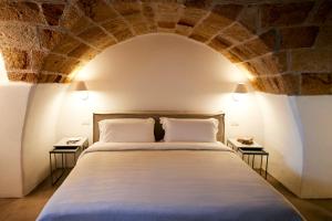 una camera con un grande letto con un muro di mattoni di Aquamarea a Polignano a Mare