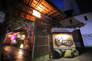 a gate to a building with graffiti on it at night at Dougoya in Matsuyama