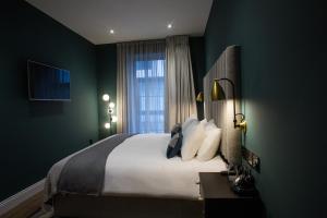 een slaapkamer met een groot bed en een raam bij The Bedford Townhouse in Limerick