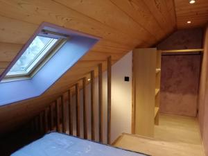an attic room with a staircase and a window at Studio en Duplex Renové in Thônes