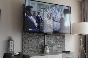 TV de pantalla plana colgada en la pared en Appartement in Sankt Englmar mit KlimaWärmetauscher en Sankt Englmar