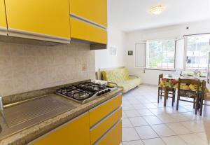 een keuken met gele kasten en een fornuis met oven bij Angela in Bibione +8 foto's