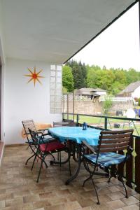 a patio with a blue table and chairs on it at Ferienwohnung Pascale in Mettlach