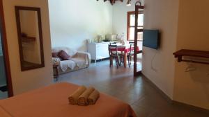 a living room with a bed and a kitchen with a table at Bangalôs Parque Verde in Paraty