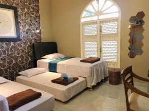 a room with two beds and a window at Argya Guesthouse in Yogyakarta
