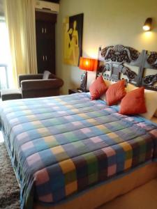 a bedroom with a large bed with a colorful blanket at Intan Mutiara Sanur Beach Villa in Sanur