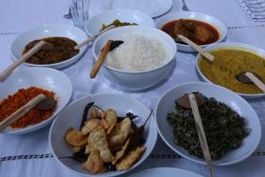 einen Tisch mit Schalen verschiedener Arten von Lebensmitteln in der Unterkunft Blue Lake Ridge in Maha Oya