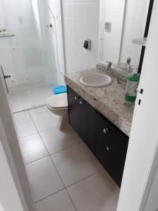 y baño con lavabo, aseo y espejo. en Esquina da Av Brasil, en Balneário Camboriú