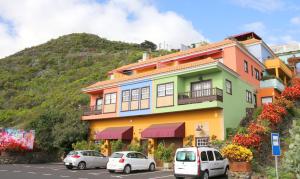a colorful house with cars parked in front of it at Vivienda Vacacional Camino del Senderista in Lodero