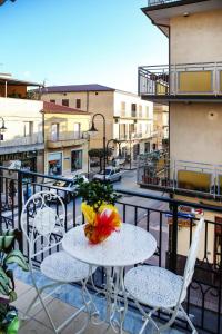 a table and chairs on a balcony with a view of a city at APRILE Bed and Breakfast in Campora San Giovanni