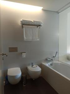 a bathroom with a toilet and a tub and a sink at YingYing Apartamento with a free parking space in Lisbon