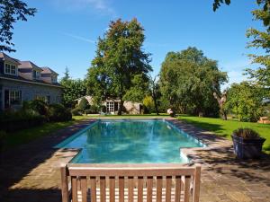 a swimming pool with a bench next to a house at B&B La Buissonniere in Xhoris