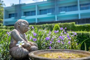
a statue of a woman sitting in front of a pot of flowers at Patong Bay Hill Resort - SHA Plus in Patong Beach
