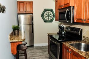 a kitchen with a sink and a refrigerator at Blue Waters Treasure Island in St Pete Beach