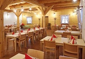 ein Restaurant mit Tischen und Stühlen mit roten Servietten darauf in der Unterkunft Penzion a restaurace Grunt in Řeka